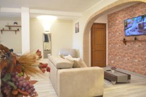 un soggiorno con divano e muro di mattoni di Entire apartment in villa with parking a Frascati