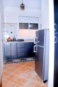 a kitchen with a stainless steel refrigerator and a tile floor at Airport apartment 2 
