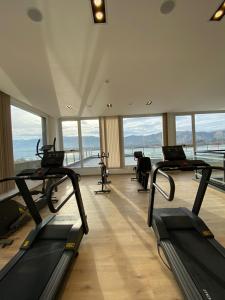 a gym with treadmills in a building with windows at Veneto Village Resort & Spa in Villa Carlos Paz