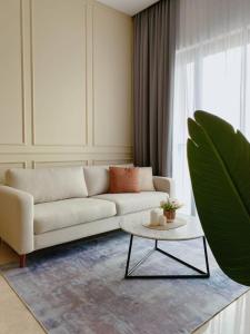 a living room with a white couch and a table at BBCC Apartments At Lucentia in Kuala Lumpur