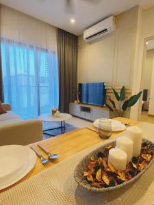 ein Wohnzimmer mit einem Tisch mit Essen drauf in der Unterkunft BBCC Apartments At Lucentia in Kuala Lumpur