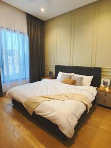 ein Schlafzimmer mit einem großen Bett mit weißer Bettwäsche in der Unterkunft BBCC Apartments At Lucentia in Kuala Lumpur