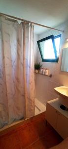 bagno con tenda per la doccia e finestra di My casa Lanzarote a Costa Teguise