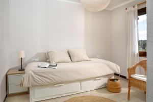 um quarto branco com uma cama e uma janela em Flateli Begur Muntanya em Begur