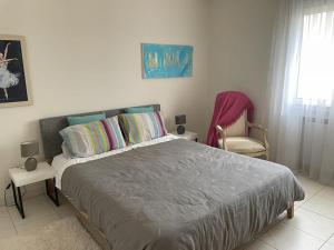 a bedroom with a large bed and a chair at Beautiful Apartement with Lakeview in Tunis