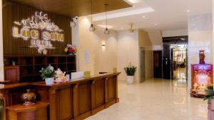 a large hotel lobby with a reception desk and a store at Lộc Sơn Hotel in Buon Ma Thuot