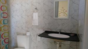 a bathroom with a sink and a toilet and a mirror at Chalés do Otto e Karine in Canoa Quebrada +59 photos