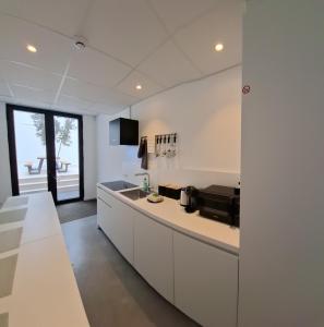 a kitchen with white cabinets and a counter top at Huis ALNA 5 in Mechelen