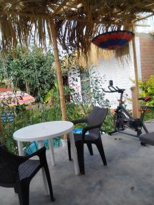 uma mesa e duas cadeiras e uma mesa e uma bicicleta em Bugambilia house em Ica
