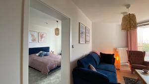 a bedroom with a blue couch and a bed at Apartament Superior PINEA 501 in Pobierowo
