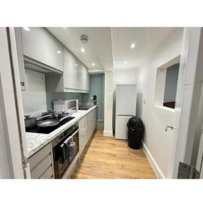 a kitchen with a sink and a refrigerator at FB- Spacious 2 Bed Flat Near Edgware Road in London
