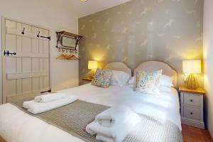 1 dormitorio con 1 cama con toallas en Birch Cleave Stable Simonsbath, en Simonsbath