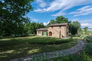 a brick house in a field with a yard at Casa Ilenia in Marciano
