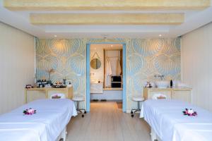 two beds in a room with blue and yellow wallpaper at The Nai Harn in Nai Harn Beach