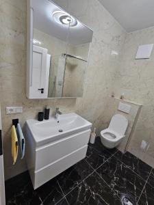 a bathroom with a white sink and a toilet at Apartamente Rognean in Wölfnitz