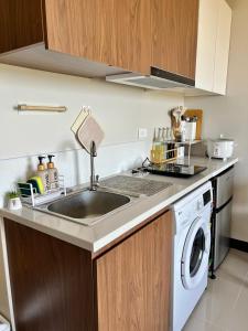 a kitchen with a sink and a washing machine at Condo in Lapu-Lapu City in Lapu Lapu City