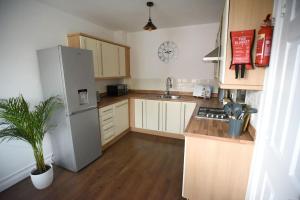 a small kitchen with a refrigerator and a sink at Modern 4 bed - Lincoln - Parking in Lincoln