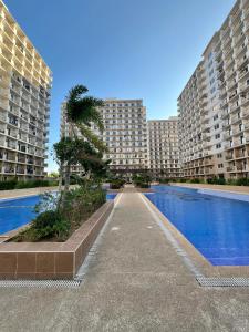 a large apartment building with a swimming pool in front of it at Condo in Lapu-Lapu City in Lapu Lapu City