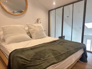 1 dormitorio con 1 cama con espejo en la pared en Charmant Loft moderne au coeur de Hyères, en Hyères