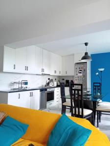 a kitchen with white cabinets and a table and chairs at Down town house with uni sence! in Athens