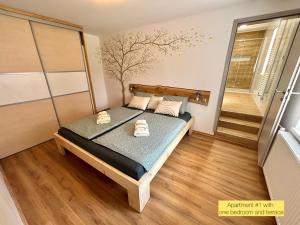 a small bedroom with a bed with a tree mural on the wall at Hurja Apartments in Kobarid
