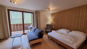 a bedroom with a bed and a couch and a window at Fatrapark Apartments House 2 in Ružomberok