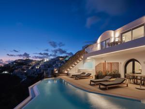 伊亚Olvos Luxury Suites的夜晚带泳池的别墅