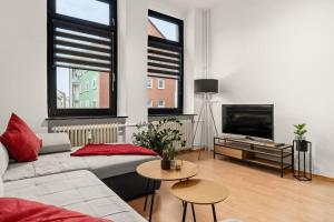 a living room with a couch and a flat screen tv at Zentrales Apartment – 2 Boxspringbetten – Netflix in Kassel