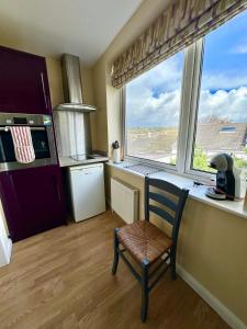 a kitchen with a chair in front of a window at Torbay Annexe in Torquay