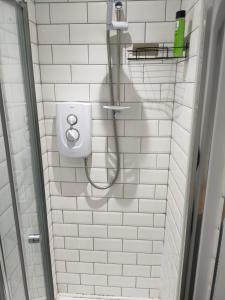 uma casa de banho em azulejos brancos com um chuveiro e um WC. em Beautiful Double Bedroom em Liverpool