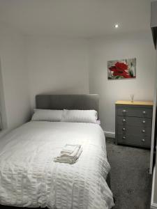 a bedroom with a white bed and a dresser at Beautiful Double Bedroom in Liverpool
