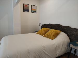 杜埃的住宿－ღ Le Loft • Spacieux, Situé au cœur de Douai，卧室配有白色床和2个黄色枕头
