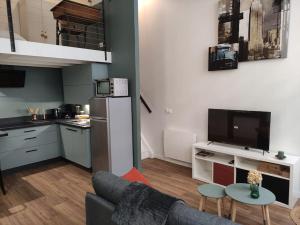 a living room with a couch and a kitchen at ღ Le Loft • Spacieux, Situé au cœur de Douai in Douai
