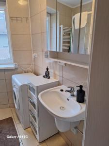 a bathroom with a sink and a washing machine at Apartament z basenem do 8 miejsc noclegowych in Ustronie Morskie