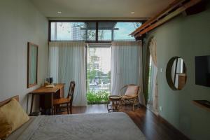 a bedroom with a bed and a desk and a window at Nhà bình Homestay in Da Nang