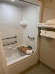a bathroom with a bath tub with towels and a shelf at Comfort Inn & Suites West Chester - North Cincinnati in West Chester