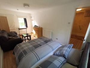 salon z łóżkiem i kanapą w obiekcie Beautiful Airbnb with Ensuite Rooms w mieście Shenley Church End