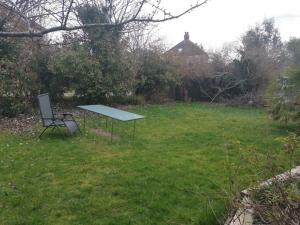 a picnic table and a chair in a yard at Beautiful Airbnb with Ensuite Rooms in Shenley Church End