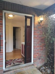 a brick house with a door and a hallway at Beautiful Airbnb with Ensuite Rooms in Shenley Church End