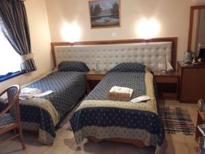 um quarto de hotel com duas camas com uma bandeja em cima em Studios Cosmopolitan em Panagioúda