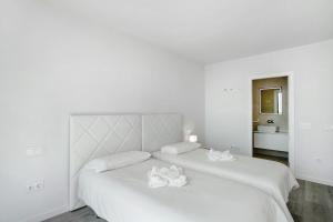 een witte slaapkamer met 2 witte handdoeken op een bed bij Wonderful penthouse city and beach in Las Palmas de Gran Canaria