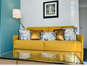 un soggiorno con divano giallo e tavolo in vetro di Proche Avignon au calme a Les Angles Gard