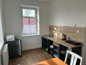 una pequeña cocina con escritorio y ventana en Apartmán Krkovička, en Mikulášovice