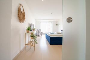 een witte slaapkamer met een bed en een tafel en stoelen bij App 14 Entspannen im Wellengang! in Dranske