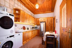 a kitchen with wooden cabinets and a white appliance at PERİ CAVE KONAK in Nevsehir