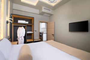 a bedroom with a bed and a flat screen tv at Acer Living Home Cappadocia in Ortahisar