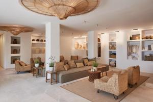 sala de estar con sofá y sillas en Barefoot Hotel Mallorca en Portocolom