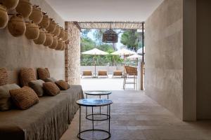 uma sala de estar com um sofá e uma mesa em Barefoot Hotel Mallorca em Porto Colom