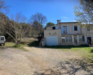 a house with a van parked in front of it at Maison au Colorado Provençal in Rustrel