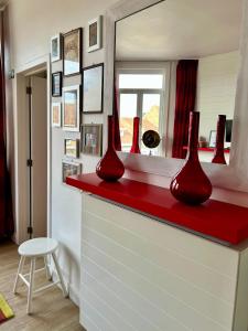 two red vases sitting on a red counter in a room at Appartement Le Lavandou in De Panne